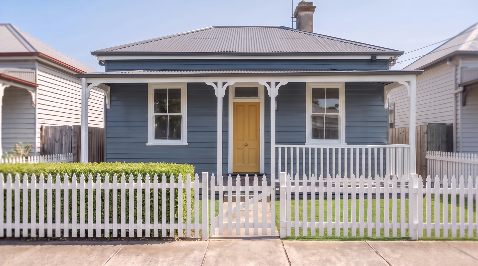 The Two Coats demo house freshly repainted in Slate, a muted blue-grey exterior