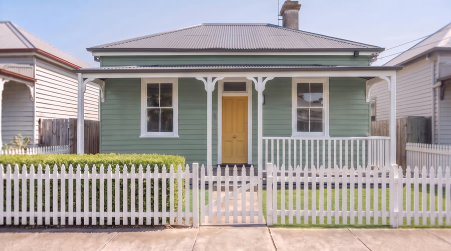 A house exterior painted in a muted eucalypt green